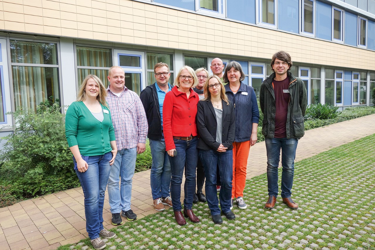 Gruppe von Menschen steht vor einem Geb&auml;ude
