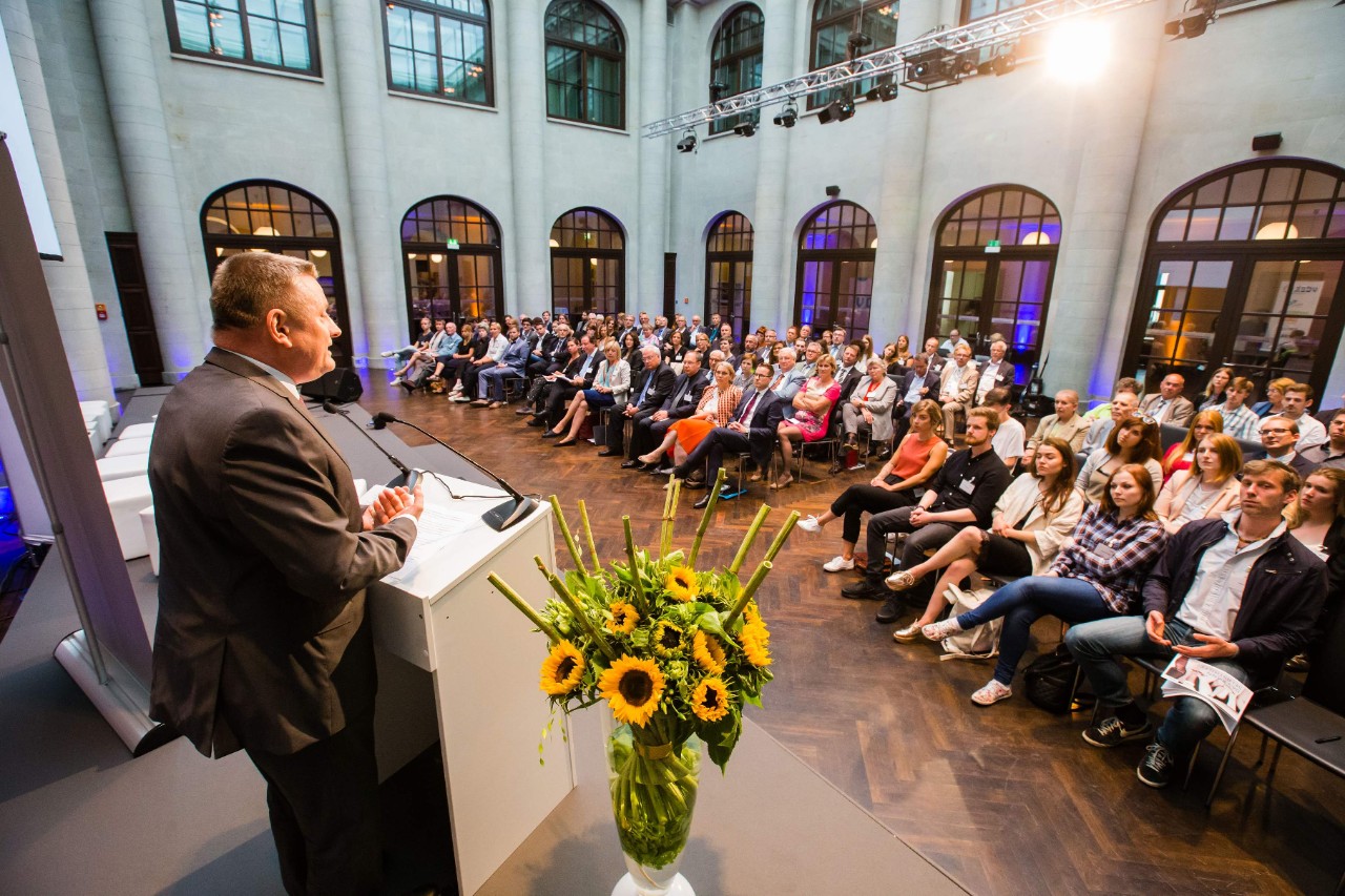 Bundesgesundheitsminister Hermann Gröhe am Rednerpult. Im Hintergrund ein Saal mit zuhörenden Gästen