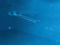 Unterwasseraufnahme zweier Krückstöcke in einem Schwimmbecken.