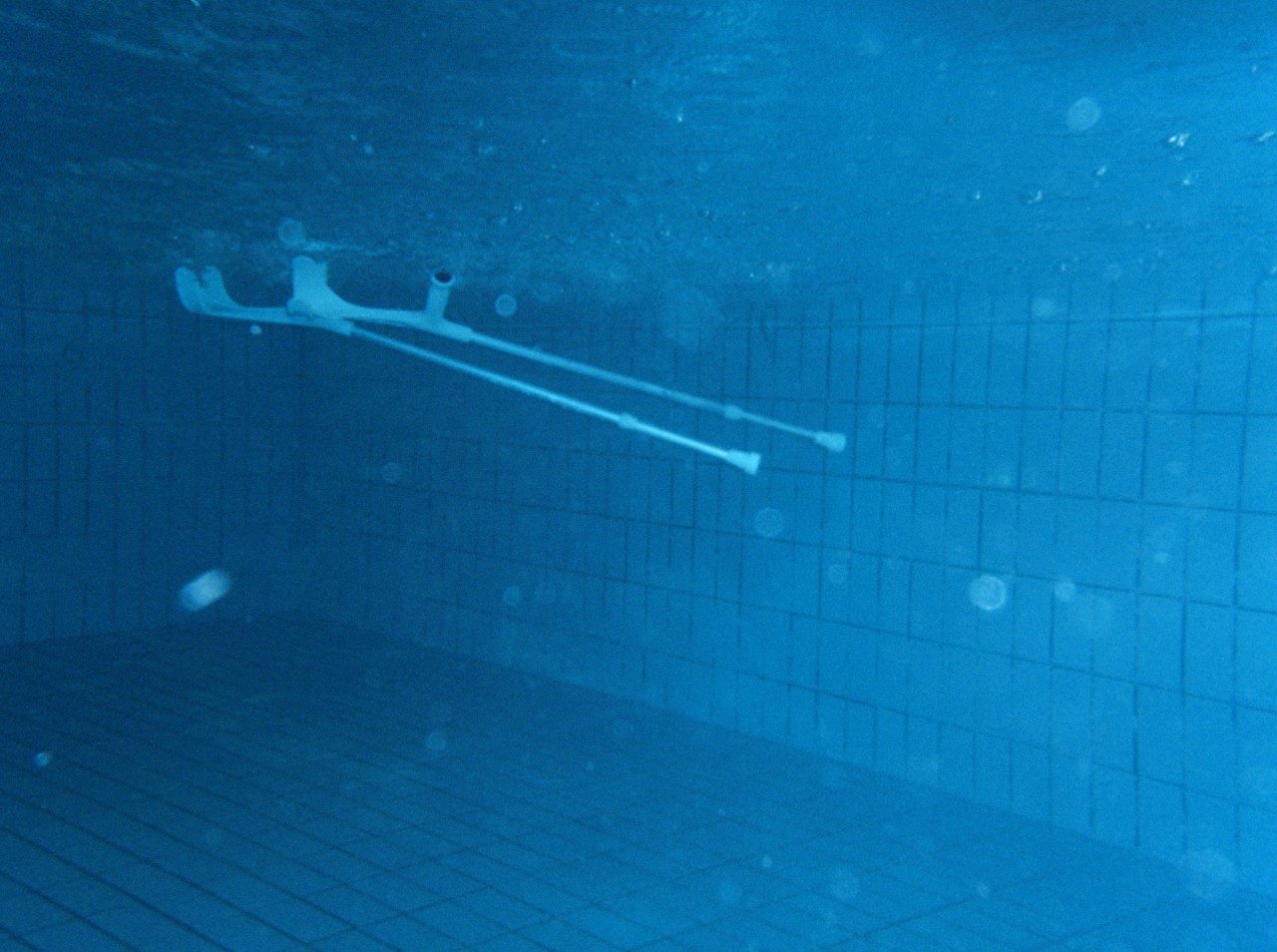 Unterwasseraufnahme zweier Krückstöcke in einem Schwimmbecken.