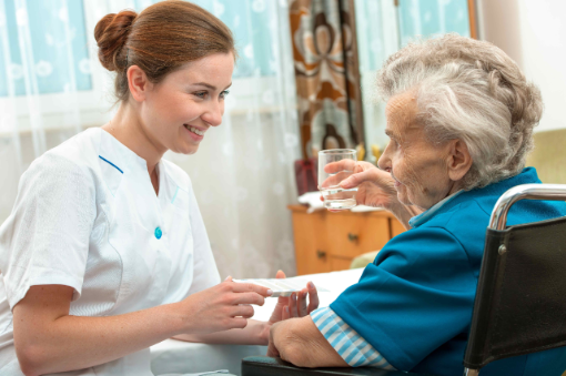 Krankenschwester gibt in Pflegeeinrichtung Medikamente an Rentnerin