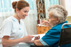 Krankenschwester gibt in Pflegeeinrichtung Medikamente an Rentnerin