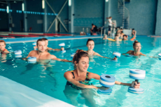 Wassergymnastik, Menschen mit Hanteln im Schwimmbecken 