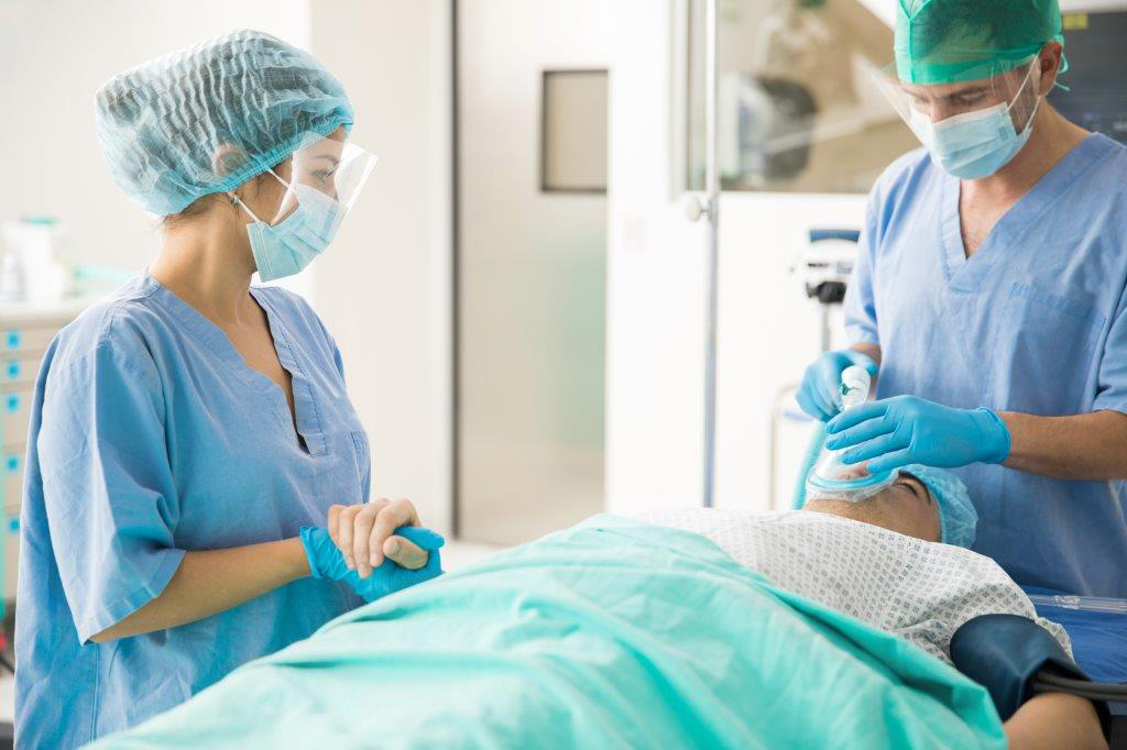 Krankenschwester bzw. Anästhesietechnische/Operationstechnische Assistentin zusammen mit Arzt und Patient vor einer Operation